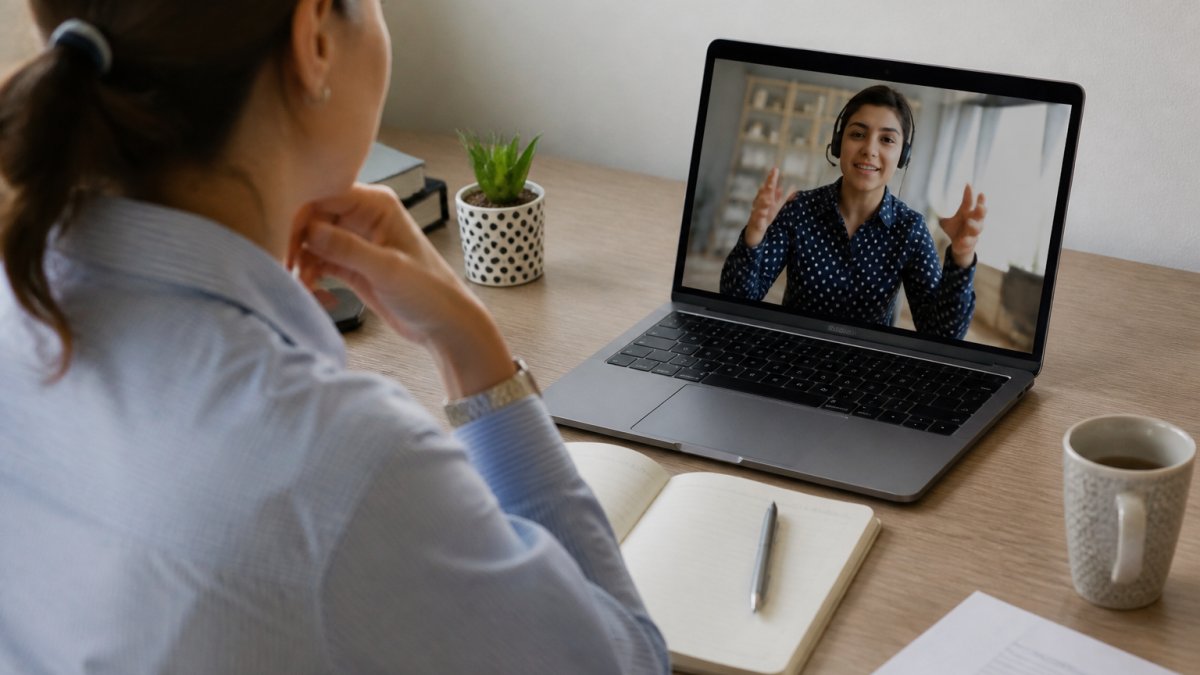 Business owner on a video call with a remote assistant while scaling an online business from a home office.